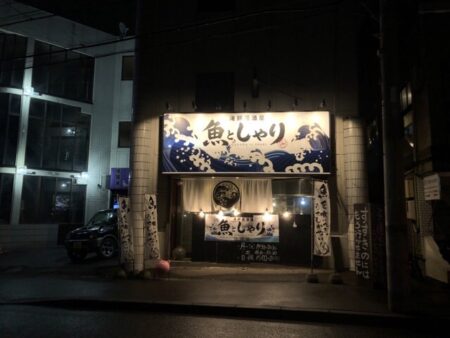 魚としゃり澄川店の夜にライトに照らされている看板