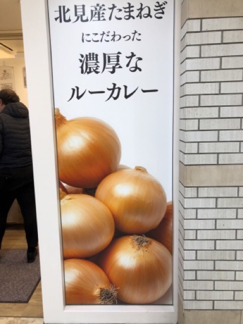 カレーのちから札幌アピア店の北見産たまねぎにこだわった濃厚なルーカレーと書いてある看板