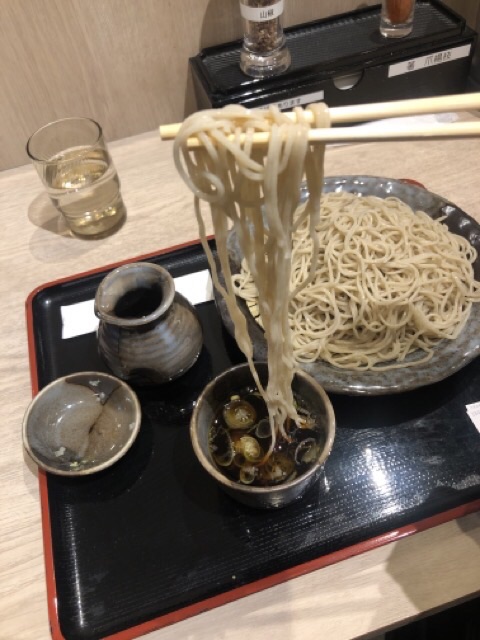 札幌の霧の下のもりそばの面を箸で持ち上げる