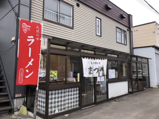 札幌の西岡のお食事の赤い幟の旗と白い暖簾のかかる店構え