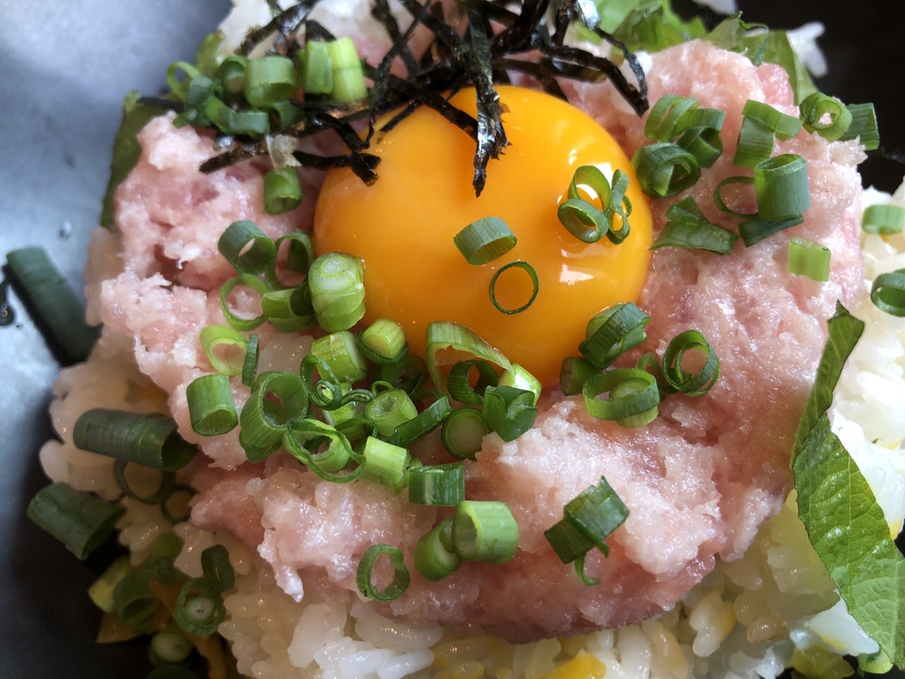札幌の祐一郎商店札幌駅前通店の本日のランチの山盛り月見トロたく丼のキミのアップ