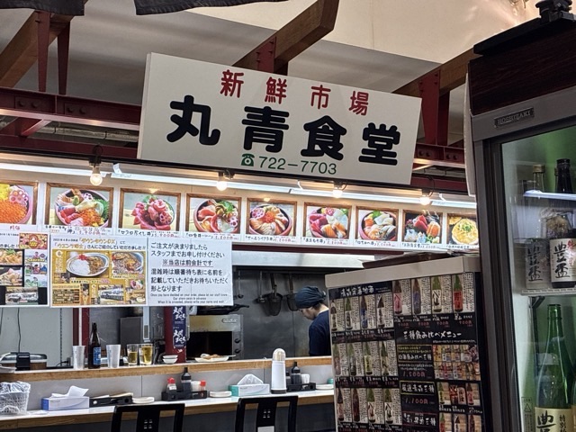 青森の新鮮市場の丸青食堂の看板が見える店構え