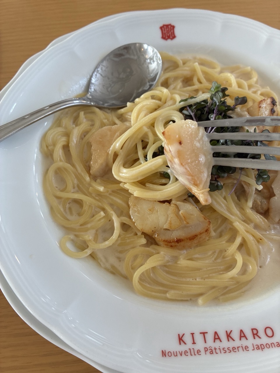 北菓楼本店2階 カフェ の野付の帆立のスパゲテホタテの貝柱をフォークで持ち上げる