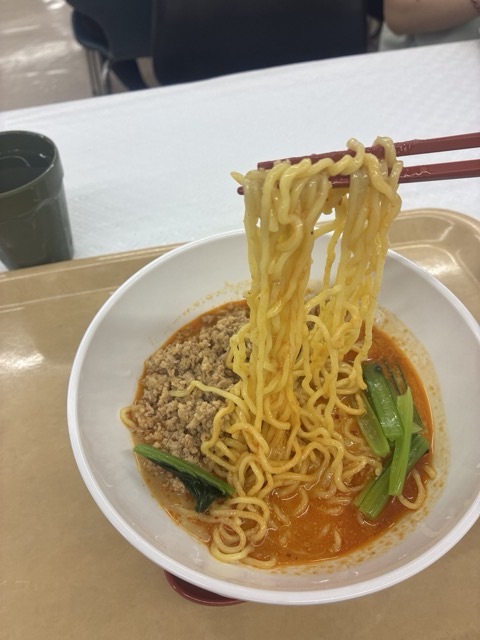 北海道庁地下食堂の特選ラーメンの冷やし豆乳担々麺の麺を箸で持ち上げる